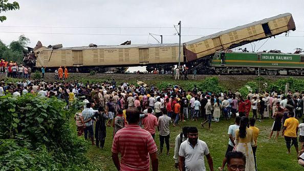 People look on at the site of a collision between an express passenger train and a goods train in Nirmaljote, near Rangapani station in India's West Bangal state on June 17, 2024