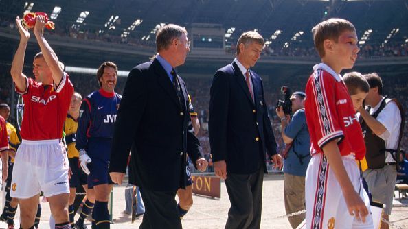 Roy Keane turns to wave to the United fans as rival managers Alex Ferguson and Arsene Wenger lead out the two teams