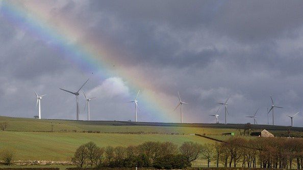 Wind turbines with rainbow in sky