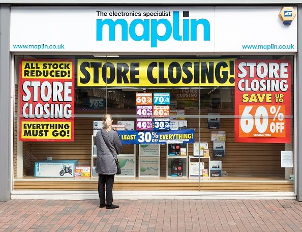 A woman looks at a store-front of Maplin's.