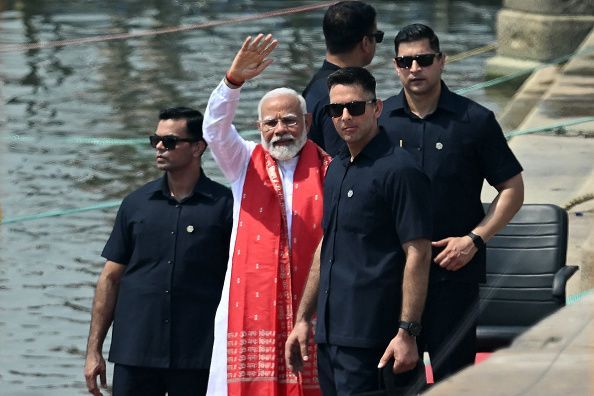 Indian Prime minister Narendra Modi (C) waves after offering prayers on the banks of the Ganges River in Varanasi on May 14, 2024, during the country's ongoing general election