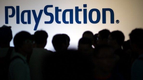 People standing in front of Playstation sign