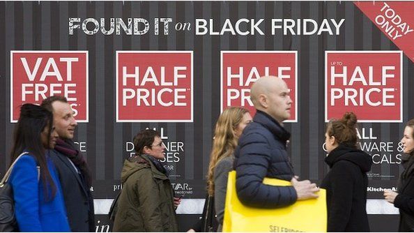 Shoppers in front of Black Friday sign