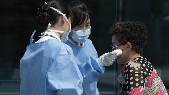 Medical staffs check the temperature of a visitor at Seoul Medical Center