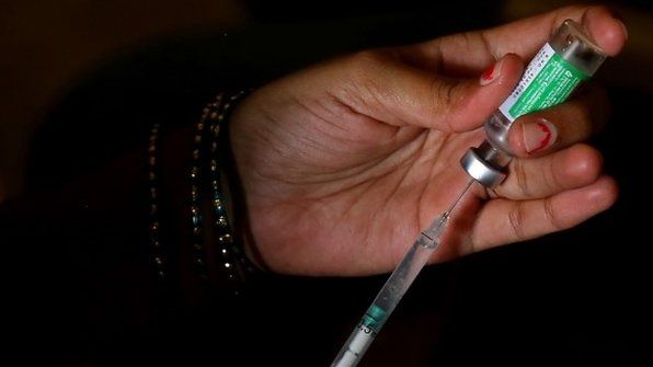A health worker draws a COVID-19 vaccine dose from a vial by using a syringe during a vaccination drive, in Bangalore, India, 28 May 2021