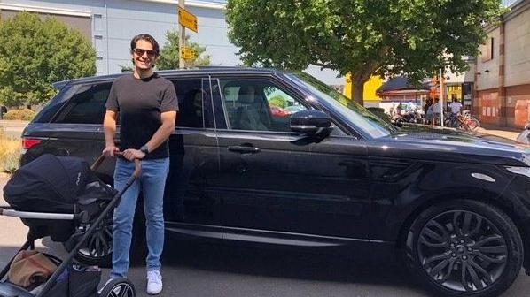 Meryl Cabellos standing wearing sunglasses with a baby buggy in front of his black Range Rover Sport