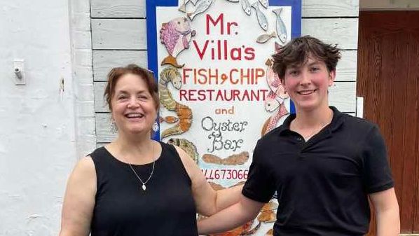 Gavin and Stacey star and writer Ruth Jones with Freddie Criddle, grandson of the owner of Mr Villa's restaurant in Barry, both smiling with arms around each other outside the restaurant