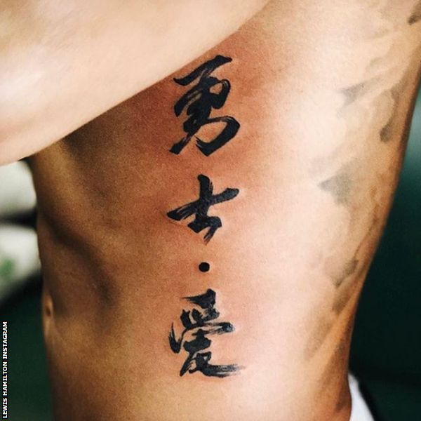 Lewis Hamilton shows off his Chinese symbol tattoo on the side of his ribs