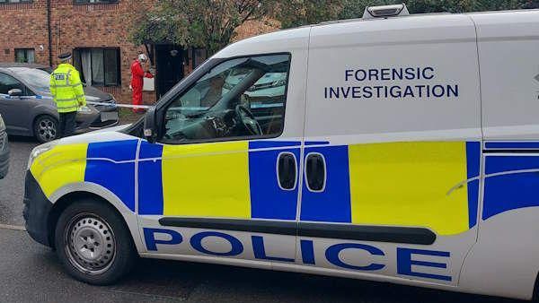 A forensic investigation police van outside a house 