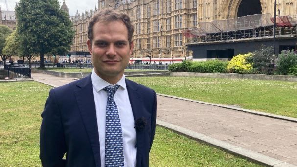 Lincoln MP Hamish Falconer smiling into the camera wearing a suit and tie