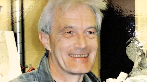 A smiling Nick Chase who has dark eyes and a quiff of white hair