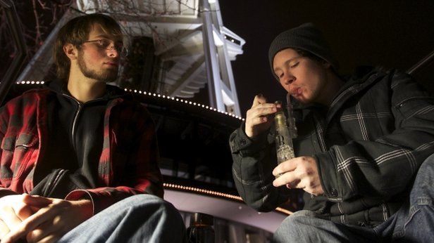 Two young men share a marijuana water pipe underneath the Space Needle in Seattle, Washington, on 6 December 2012