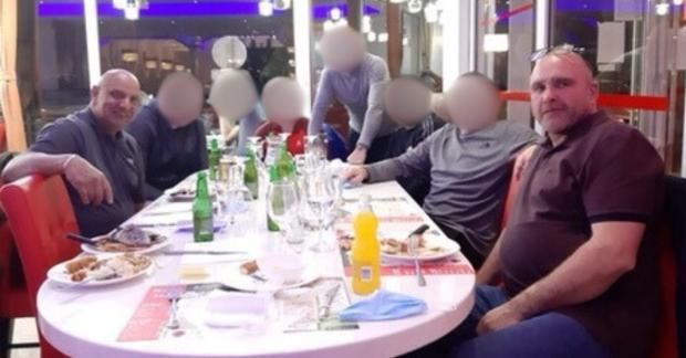 Phillip Ali and Stephen Brown sat in a restaurant eating food. There are other people in the picture and their faces have been blurred