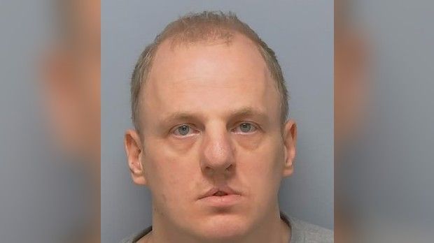 Police custody image of Adam Watson - he is staring straight at the camera.