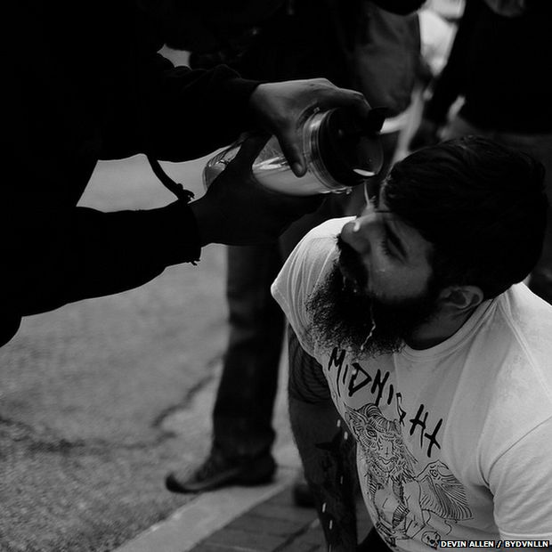 'I'm for the protesters but against the rioters,' Allen says. Underneath this photo of a white protester he wrote: 'He stood on the front lines with us and got pepper sprayed....a brother saw his pain and came to his aid with milk ::::: Deeper than skin and if you stand with us your my brother and or sister idc [I don't care] what color you are'