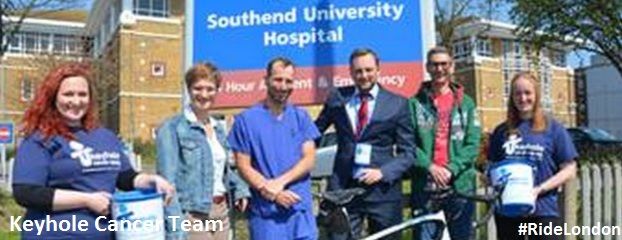 6 people in front of Southend University Hospital, 3 women and 3 men smiling one bike in front of the people