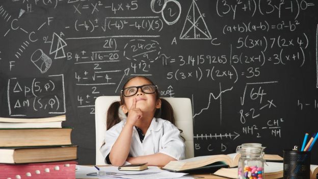 Girl sitting in front of black board