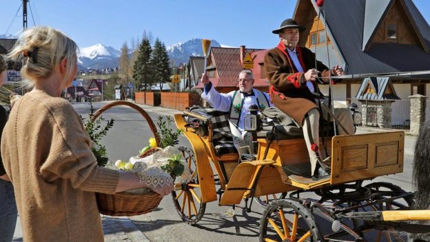 Mu mujyi wa Zakopane muri Pologne (Poland), padiri aratera amazi y'umugisha ku bakristu agendera mu cyuma gikwegwa n'ifarashi.
