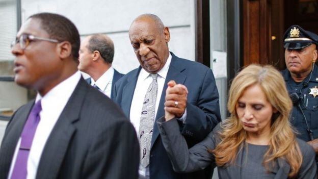 Bill Cosby holds up the hand of his defence attorneys Angela Agrusa as he exits the courthouse at the Montgomery County Courthouse on 17 June 2017 in Norristown, Pennsylvania