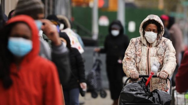 Mulher de máscara andando na rua em Nova York