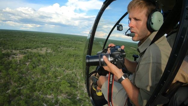 Man taking photographs from a helicopter
