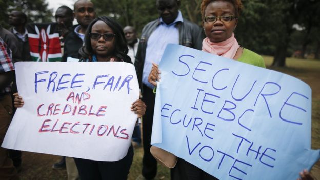 Protesters hold placards calling for free and fair elections