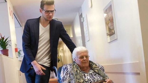 Jurrien Mentink empujando una residente en silla de ruedas