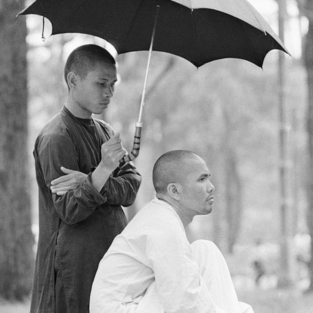 Một thành viên của nhóm phiến quân phật giáo Việt Nam che ô cho nhà sư Thích Trí Quang, người lãnh đạo nhóm năm 1967