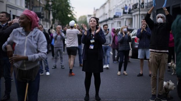 People gather on the street to clap for the NHS