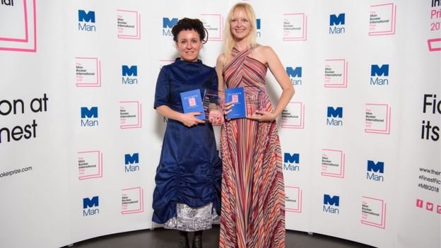 Olga Tokarczuk, left, stands with translator Jennifer Croft holding copies of Flights and the prize at the award ceremony on 22 May 2018