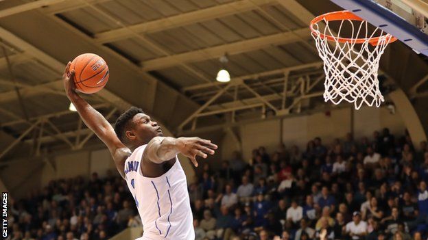 Zion Williamson leaps to make a dunk while playing for Duke University