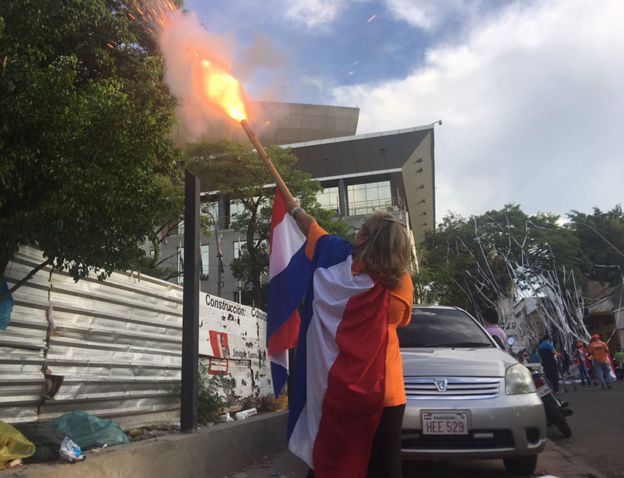 Una mujer lanza un petardo fuera del Congreso de Paraguay