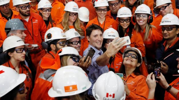 Prime Minister Justin Trudeau takes a selfie with steel workers at a steel plant in Canada