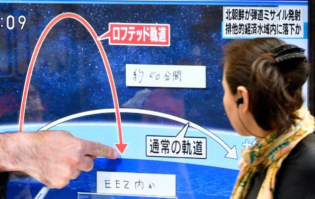 A pedestrian looks at a TV screen on a street broadcasting news of North Korea's missile launch, in Tokyo, Japan, 4 July 2017.