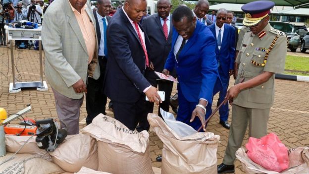Kenyan police, including Inspector General Joseph Boinnet inspect seized bags of sugar