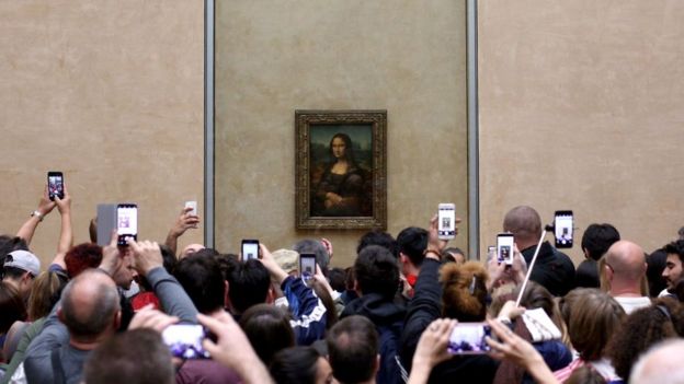 La Mona Lisa de Leonardo da Vinci siendo fotografiada con celulares en el Museo Louvre.