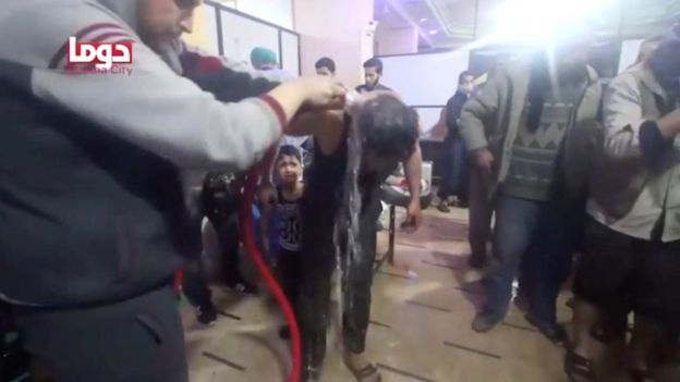 Un niño es lavado luego del supuesto ataque con armas químicas en Duma, Guta Oriental, Siria.