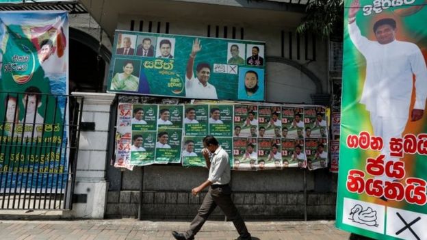 A man walks past the posters of Sajith Premadasa, Sri Lanka"s presidential candidate of the New Democratic Front alliance, in Colombo, Sri Lanka