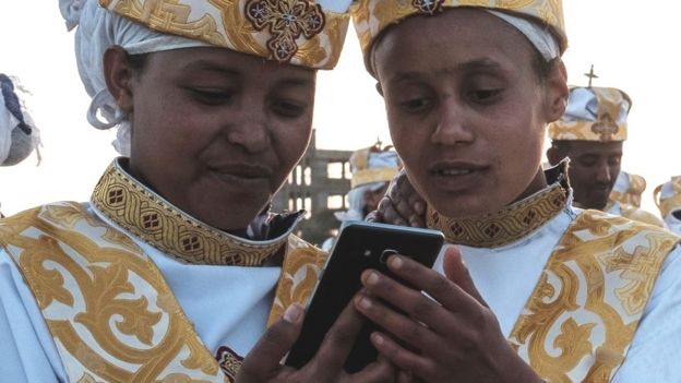 Des Éthiopiens orthodoxes utilisent des smartphones à Addis-Abeba - janvier 2019