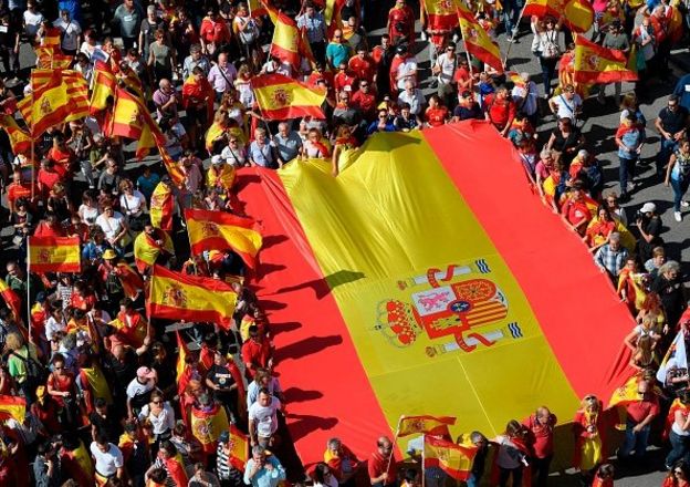 ผู้ประท้วงถือธงสเปนขนาดใหญ่ในการเดินขบวนเพื่อสนับสนุนการเอกภาพของสเปนเมื่อวันที่ 8 ตุลาคมที่ผ่านมา