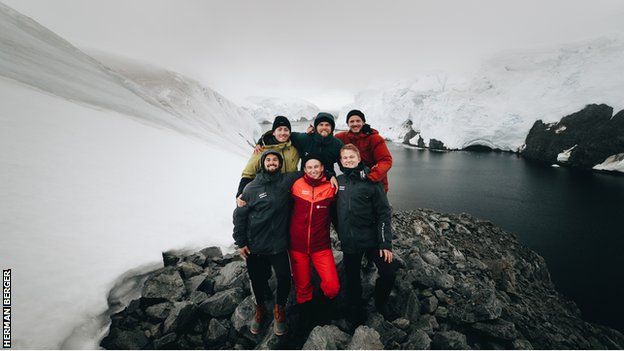 Anders Hofman and his support team pose for a photo on completion of the Ironman triathlon in Antarctica