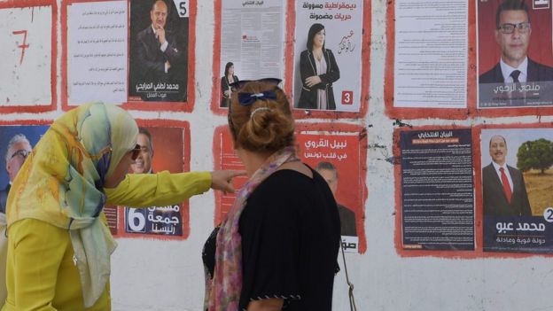 سيدتان تطالعان الملصقات الدعائية للمرشحين