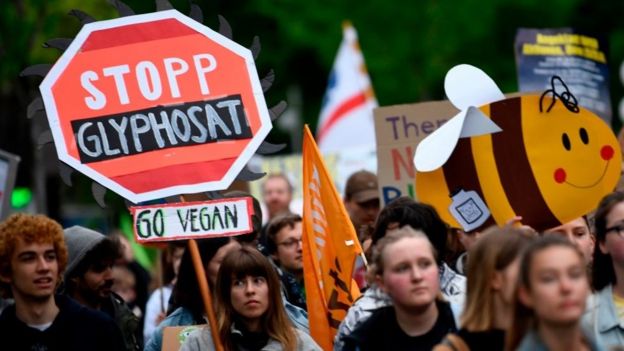 A protestor holds a placard reading "Stop Glyphosate" during a demonstration outside the World Conference centre where the annual general meeting of German chemicals giant Bayer takes place on April 26, 2019 in Bonn, western Germany. -