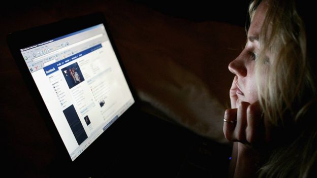 Joven mira Facebook