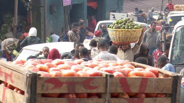 በአትክልትና ፍራፍሬ ገበያ ውሰጥ የሚታዩ ሰዎችና የምግብ ምርቶች