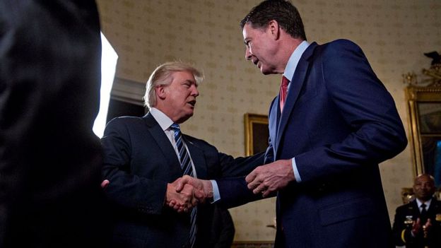 Donald Trump and James Comey shake hands.