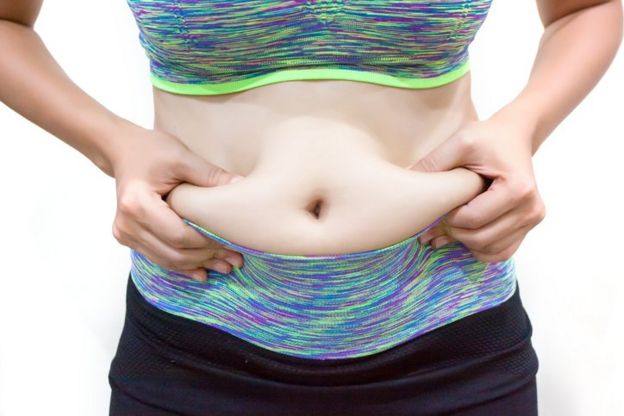 Persona mostrando su grasa abdominal