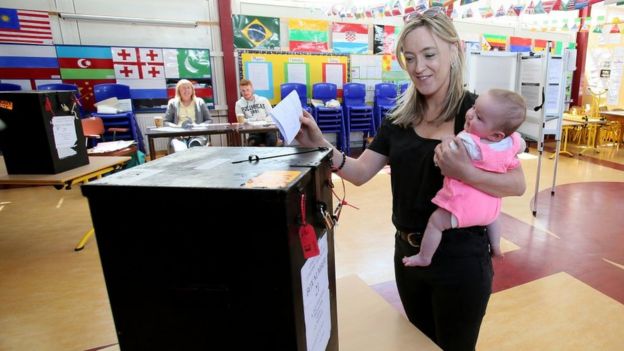 Woman carrying baby to vote