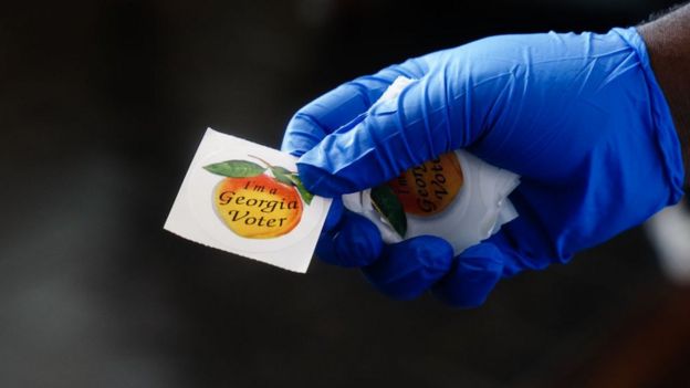 Voters are handed a sticker saying they voted