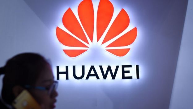 Mujer en frente del logo de Huawei.